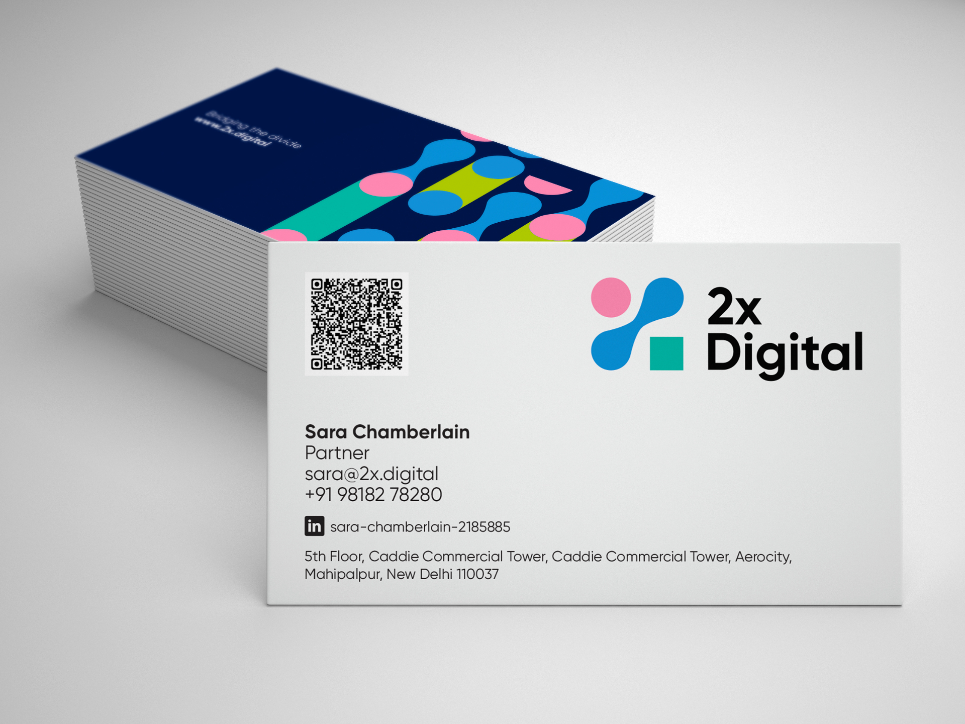 2X Digital business cards with colorful chromosome-inspired logo design on white and navy blue backgrounds