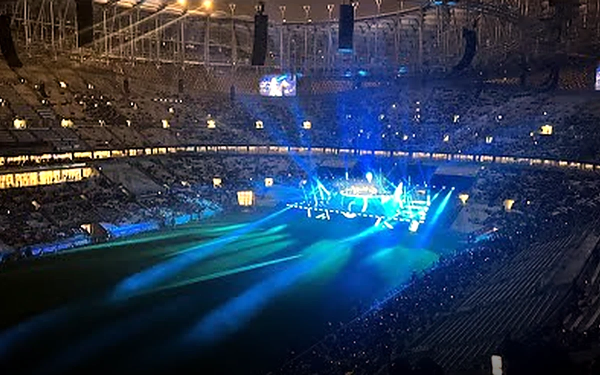 Stadium in Doha filled with cyan laser beams and a glowing central stage during a night opening ceremony — visuals created from Goa