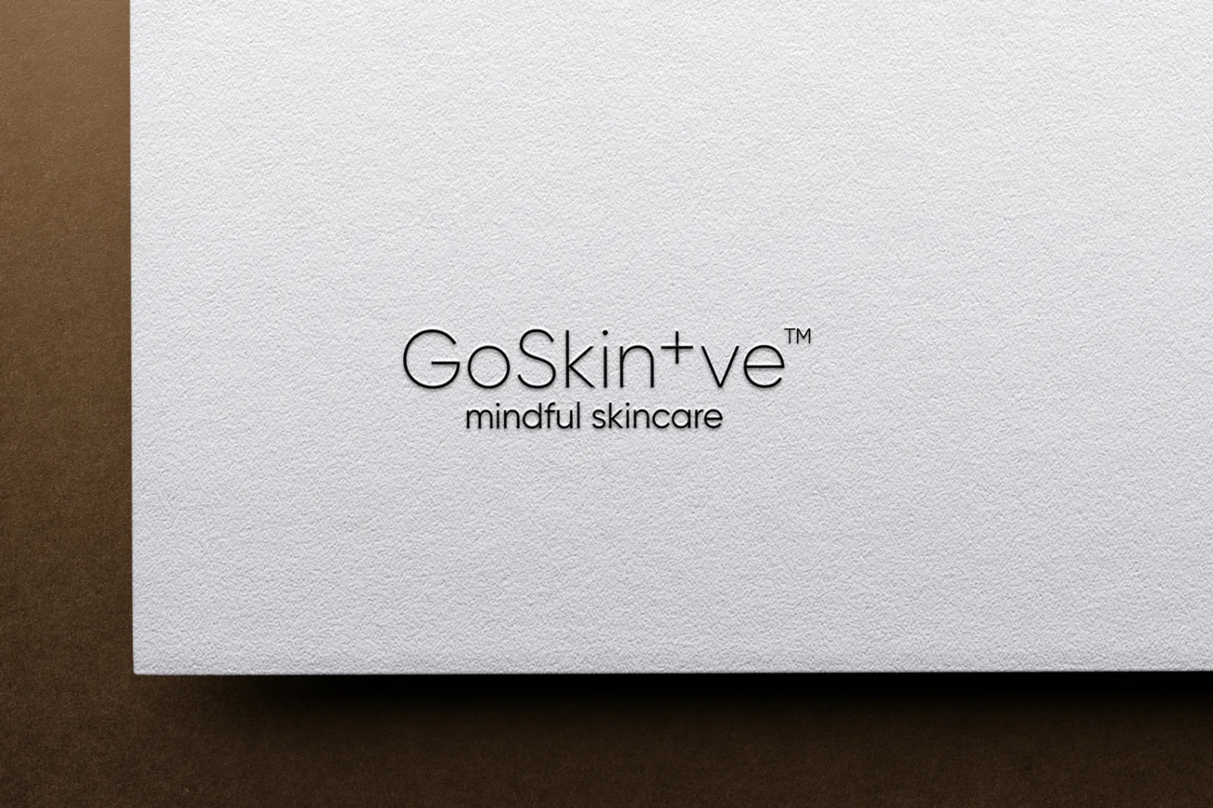 GoSkin+ve embossed logo on textured paper showcasing mindful skincare brand identity