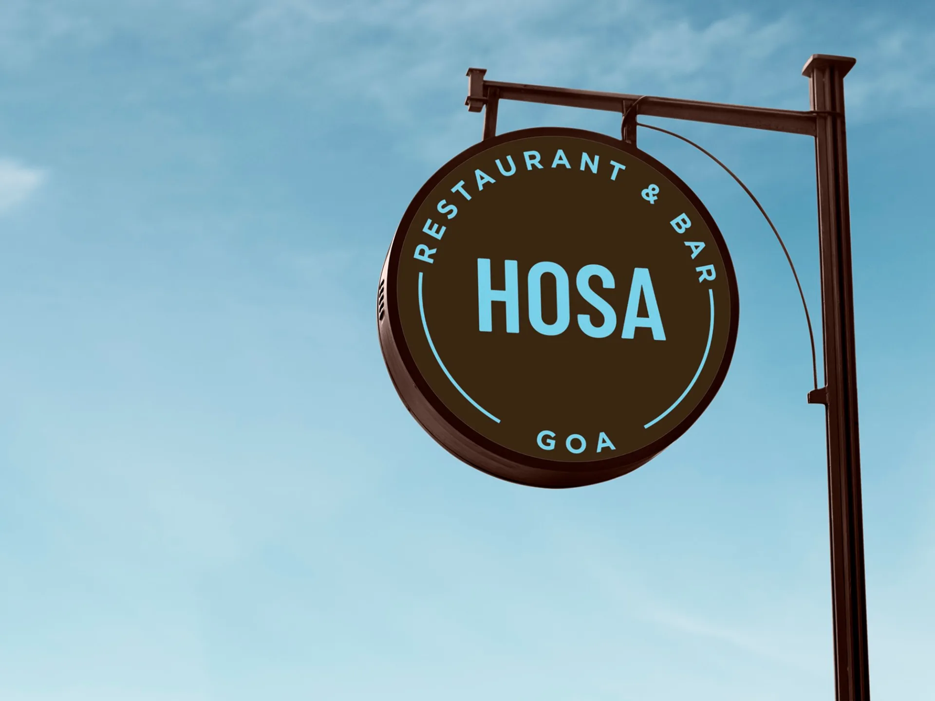 HOSA GOA - Circular restaurant signage and logo against blue sky