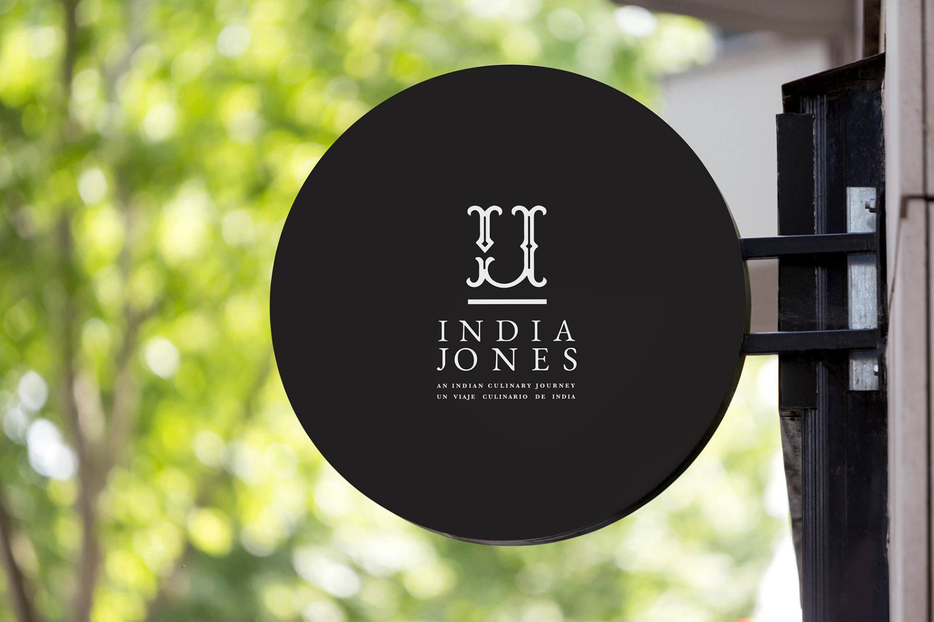 India Jones - Circular restaurant signage with black background and white logo typography