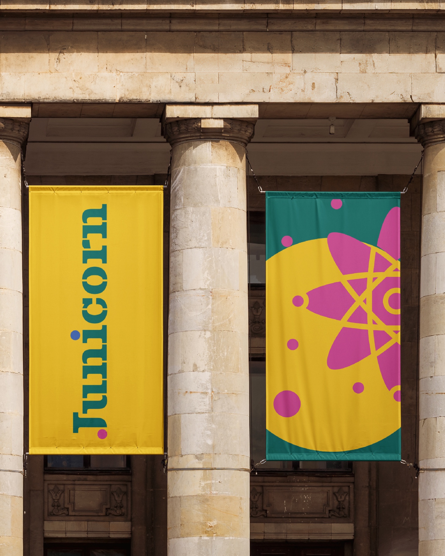 JUNICORN - Hanging banners showing wordmark and graphic elements in yellow and teal
